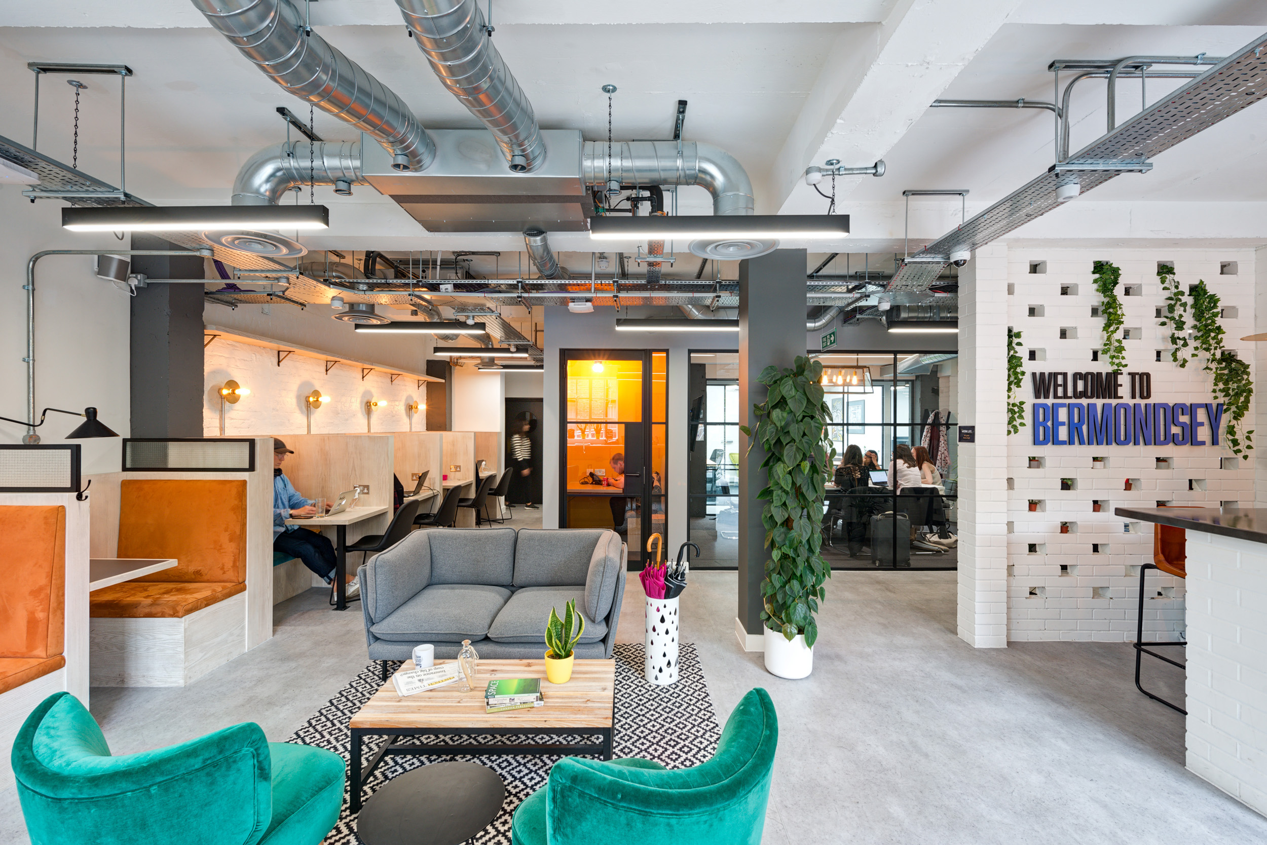 The lounge area at Work.Life Bermondsey, featuring sleek sofas and industrial-style exposed ceilings, designed by Modus Workspace.