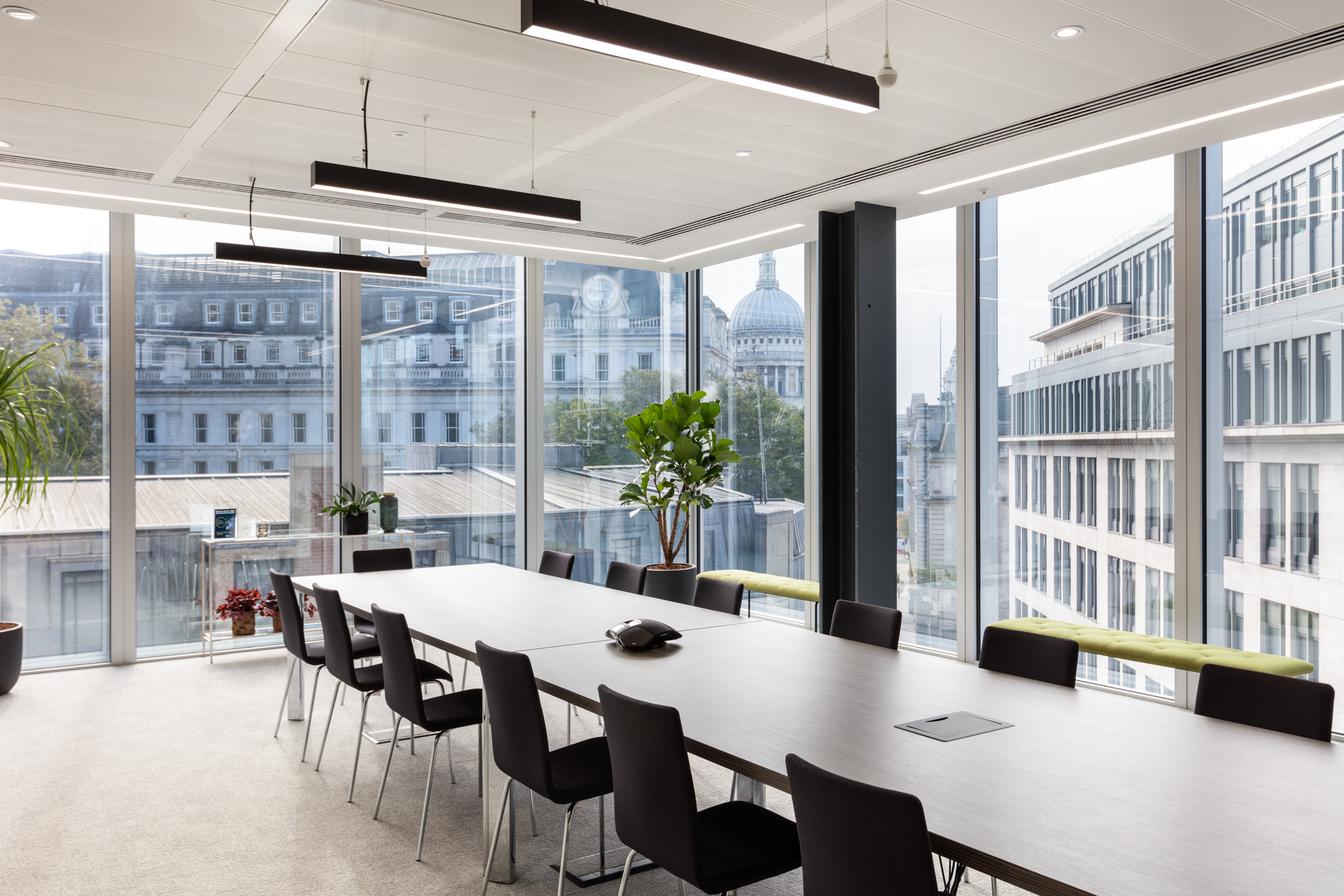 A finnCap meeting room featuring a long rectangular table and black chairs, with panoramic views of central London