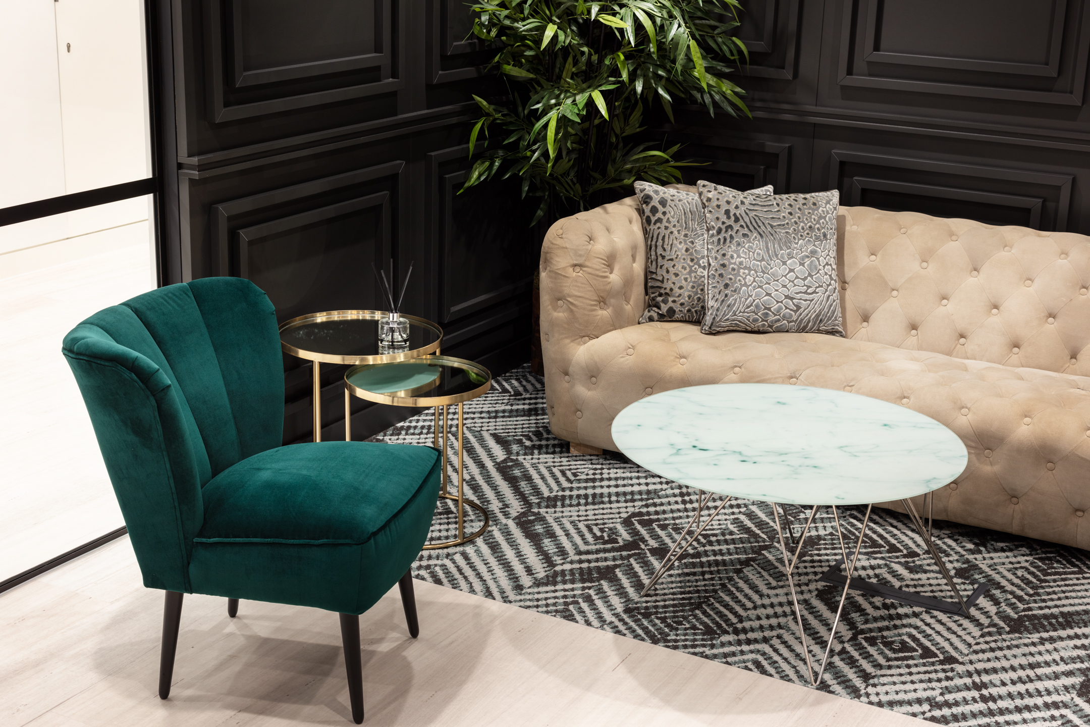 Close-up of seating in finnCap’s reception seating area, including a green velvet chair and a round marble table, with textured patterns and rich materials enhancing the luxurious feel.