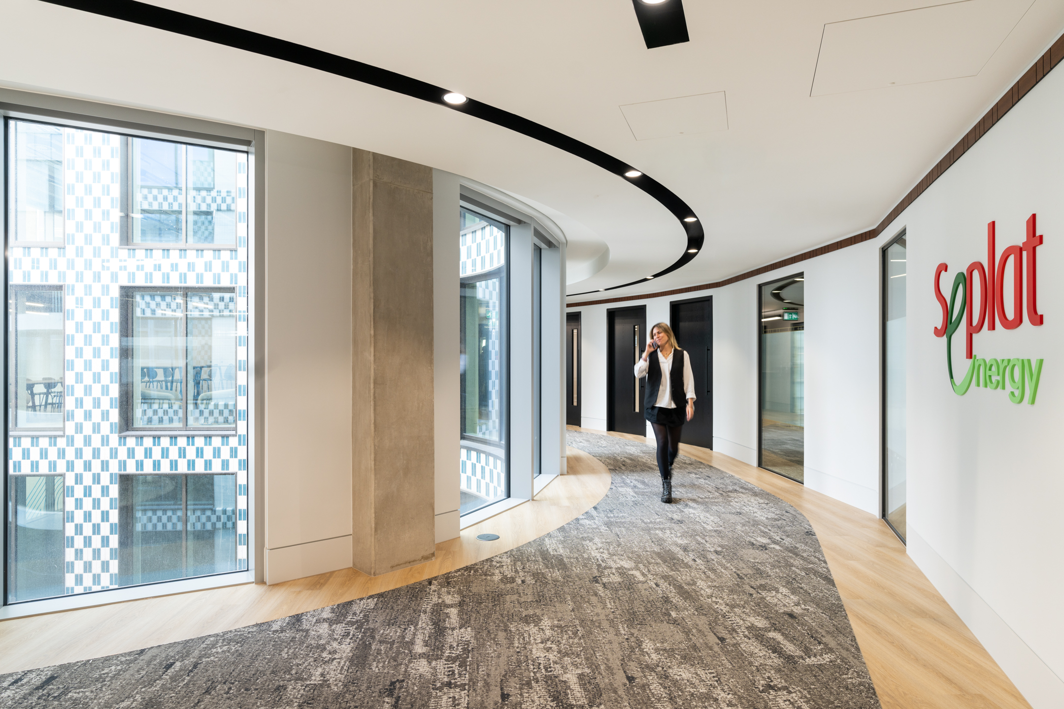 Seplat Energy corridor with curved walls, stylish carpet, and the company logo.