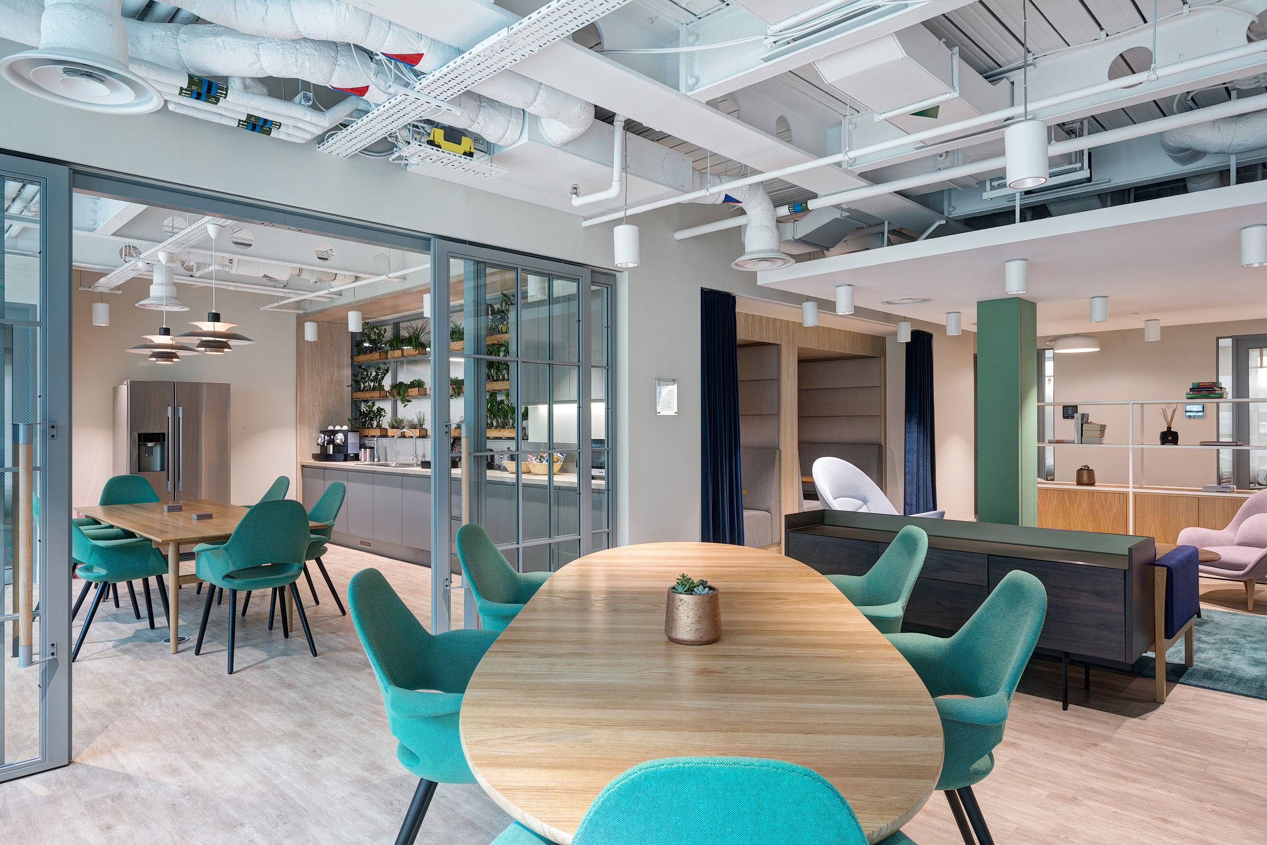 The teapoint area at Vitruvian Partners’ Marylebone office features contemporary furniture and integrated plant shelving, designed to promote collaboration and employee well-being.