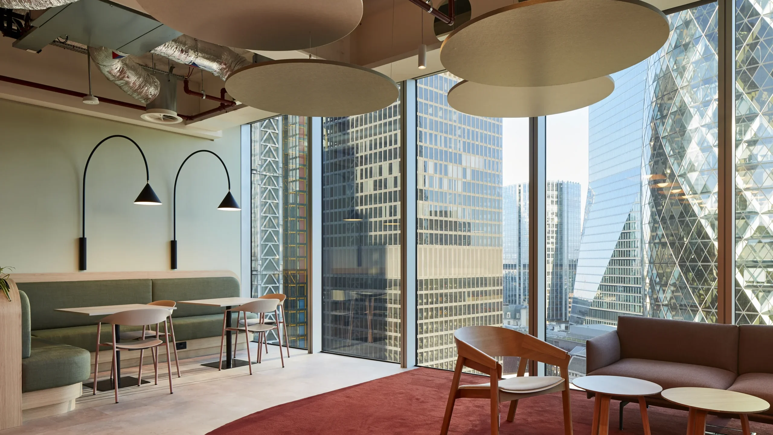 Modern meeting space with large pendant lights and a cityscape view through floor-to-ceiling windows, offering a stylish and inspiring environment.